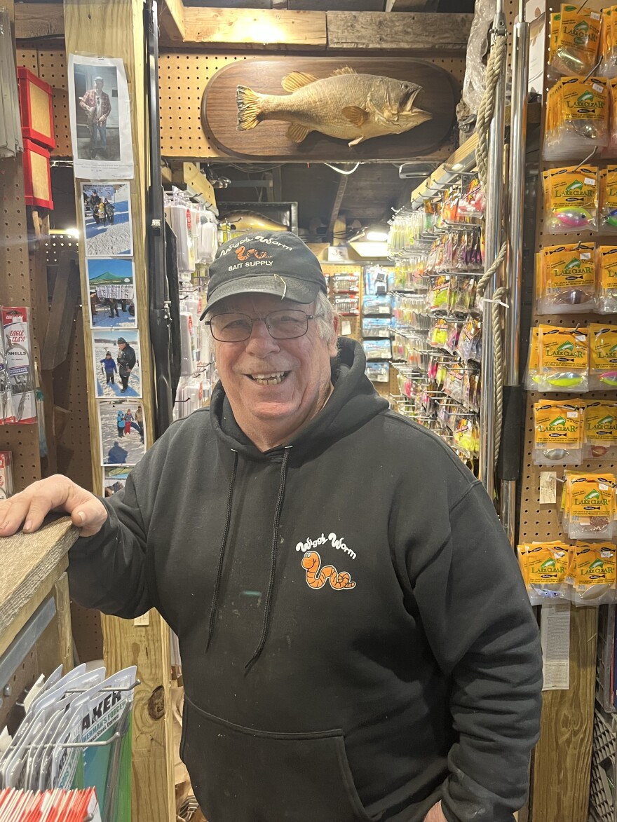 Gary Ingles poses for a photo inside the store in black clothing featuring the Wiggly Worm logo.