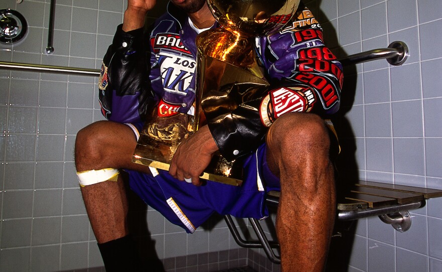 Bryant sits with the NBA Championship trophy after the Lakers defeated the Philadelphia 76ers to win the 2001 NBA title on June 15, 2001.