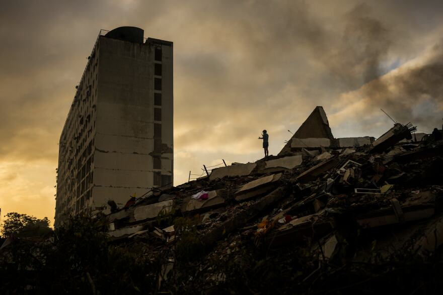 A man stands atop a mountain of rubble three days after twin earthquakes struck, in La Guaira, Venezuela, Saturday, June 27, 2026.