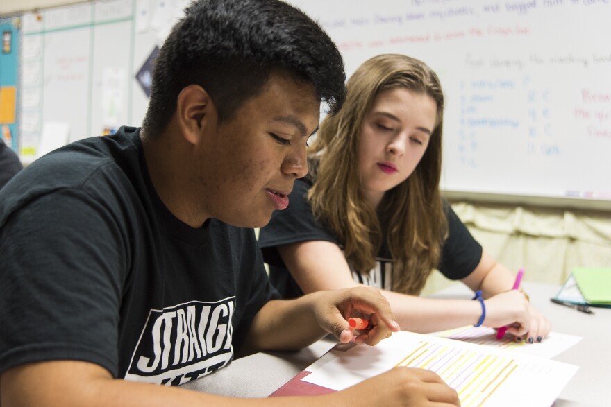 Jose talks with his fellow student Sydnee Outlaw about an assignment for their English class.