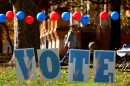 Students on the campus of the University of Pittsburgh walk past a ‘vote’ sign on Election Day, Nov. 5., 2024. (Jared Whickerham/for Spotlight PA)