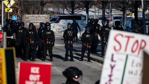 U.S. Customs and Border Protection officers stand by as dozens of people protest outside the Bishop Henry Whipple Federal Building near the Twin Cities airport last week. CBP is working on the immigration crackdown that's being overseen by U.S. Immigration and Customs Enforcement, or ICE.