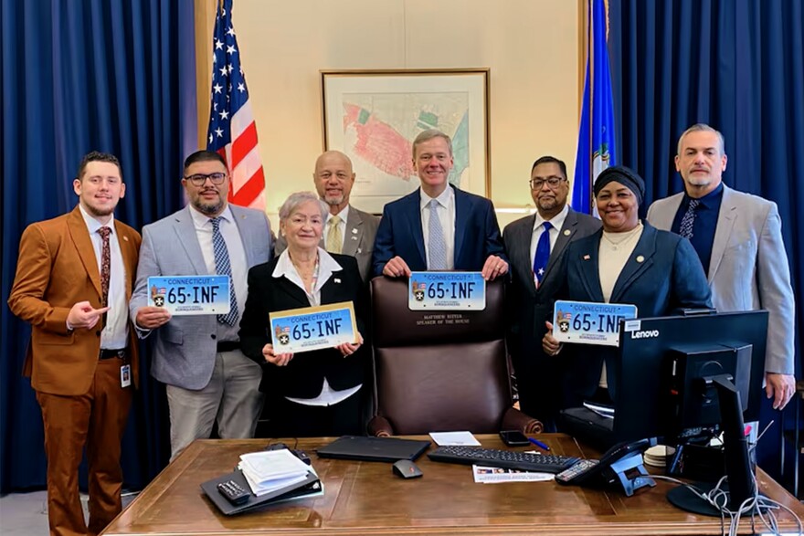 El representante Geraldo Reyes (a la derecha, con espejuelos) fue el copatrocinador de la medida. En la foto aparecen varios legisladores, incluyendo al presidente de la Cámara, Matthew Ritter (centro).