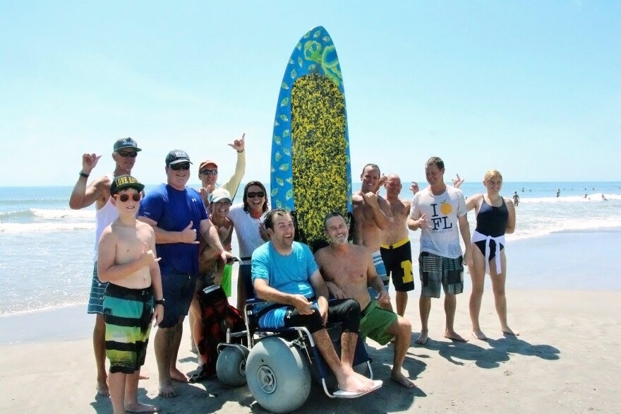 It took a team of delighted friends and family to help Florida engineer Matt Bellina (center) get back on his surfboard this summer after his severe spinal injury. The result? "I feel like I'm home," Bellina said.