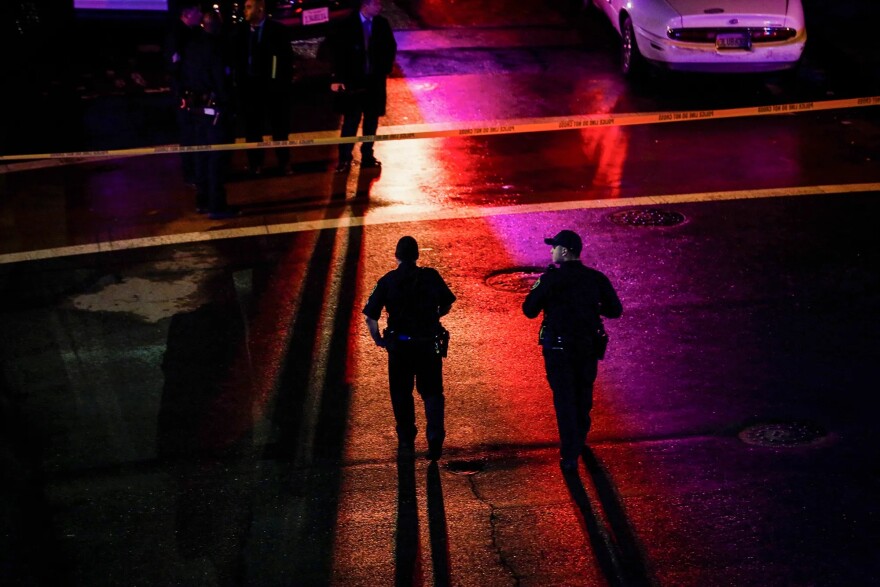 Oakland police officers walk through a crime scene outside the West Oakland BART station on Jan. 3, 2018.