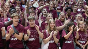 a group of students cheer in maroon URSA shirts