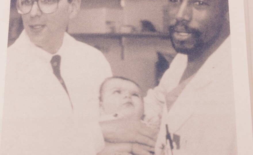 Dr. Ben Carson (right) poses with Dr. Mark Rogers and one of the Binder twins whom Carson surgically separated in a first-of-its kind operation. The twins were born conjoined at the head.
