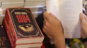 A boy reads a book next to copies of George Orwell's "1984" at Hong Kong's annual book fair in July 2015. (Aaron Tam/AFP/Getty Images)