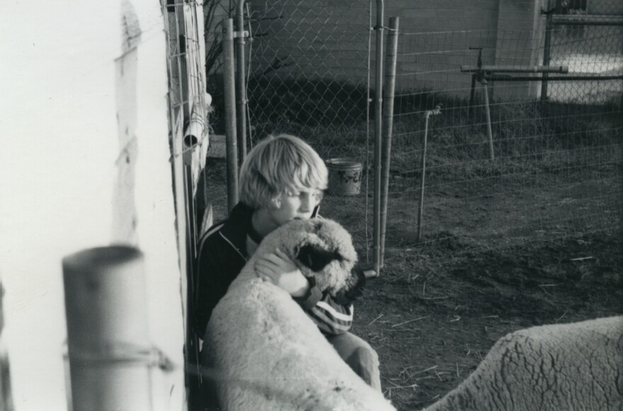 John Putz sits with a sheep.