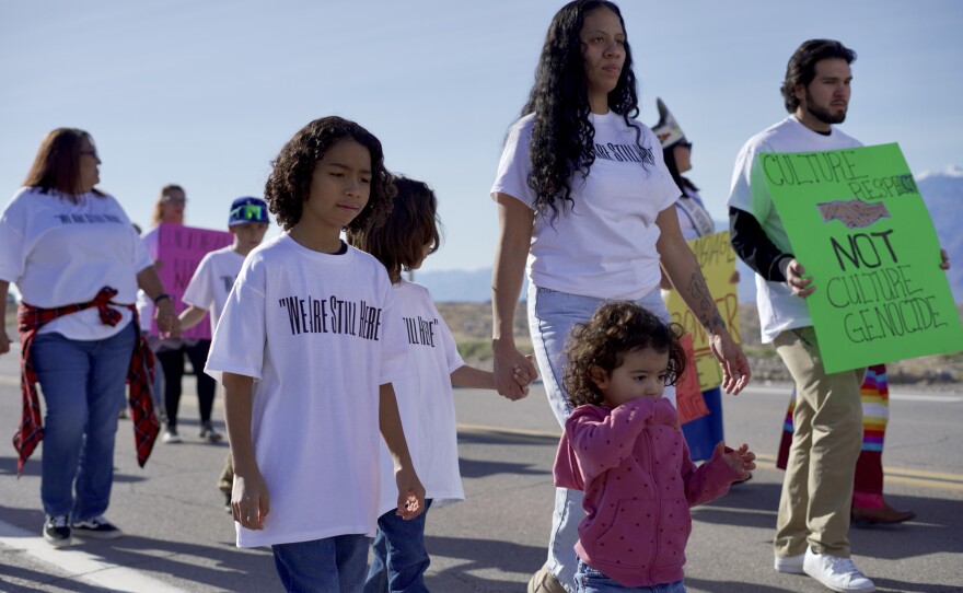 Jimmy John Thompson's grandkids march with a crowd on the main road leading to the Death Valley National Park, on Friday, January, 30, in Death Valley. (Jimmy Romo/KNPR News)
