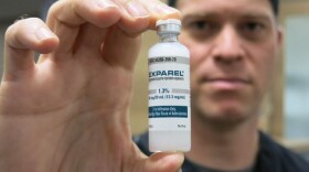Curt Hayes, an oral surgeon in Lafayette, Colorado, holds up a bottle of a Exparel, a local anesthetic that is not an opioid. (John Daley/CPR News)