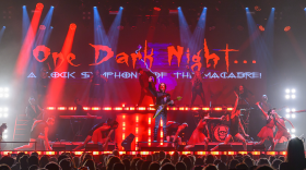 Neil Zaza and performers on stage performing a Halloween-themed show