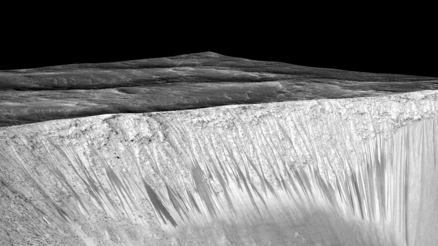 Streaks a few hundred feet in length appear on the walls of Garni crater on Mars. Scientists suspect they are formed by the flow of briny, liquid water on Mars.