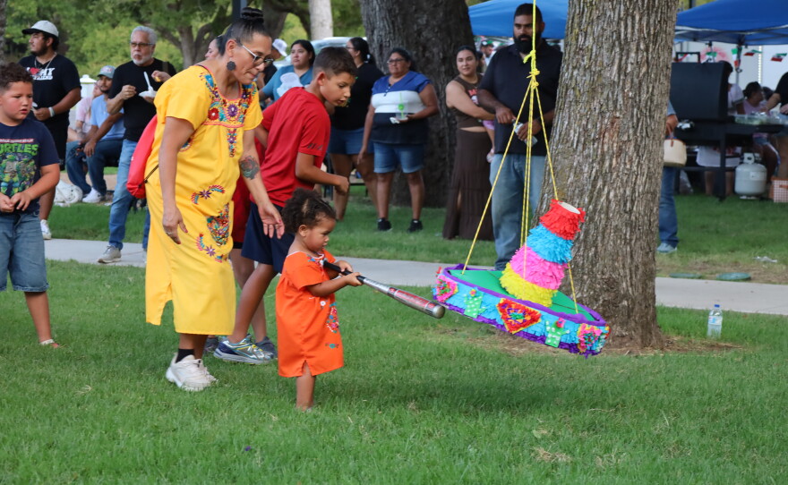Young child swinging a bat at the pinata at the 5th Annual Hispanic Heritage Celebration put on by SALSA at Riverside Park. Photo by Allison Diaz.