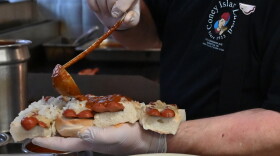 Pete Ventura ladels texas chili onto an order of hot dogs. When his father ran the shop there was only one way a hot dog could be served.