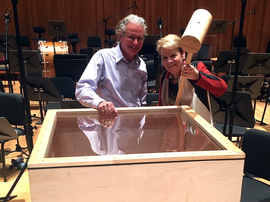 Baltimore Symphony Orchestra percussionist John Locke stands beside conductor Marin Alsop, who holds the giant hammer Gustav Mahler includes in his Sixth Symphony.