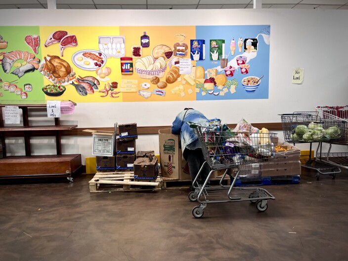 Ann selects a watermelon from the Capuchin Soup Kitchen food pantry amidst uncertainty around SNAP benefits due the federal government shutdown. We're identifying only by her first name, Ann, to protect her family's privacy.