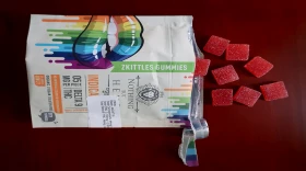 THC gummies spill out of a package labeled "Zkittles Gummies"