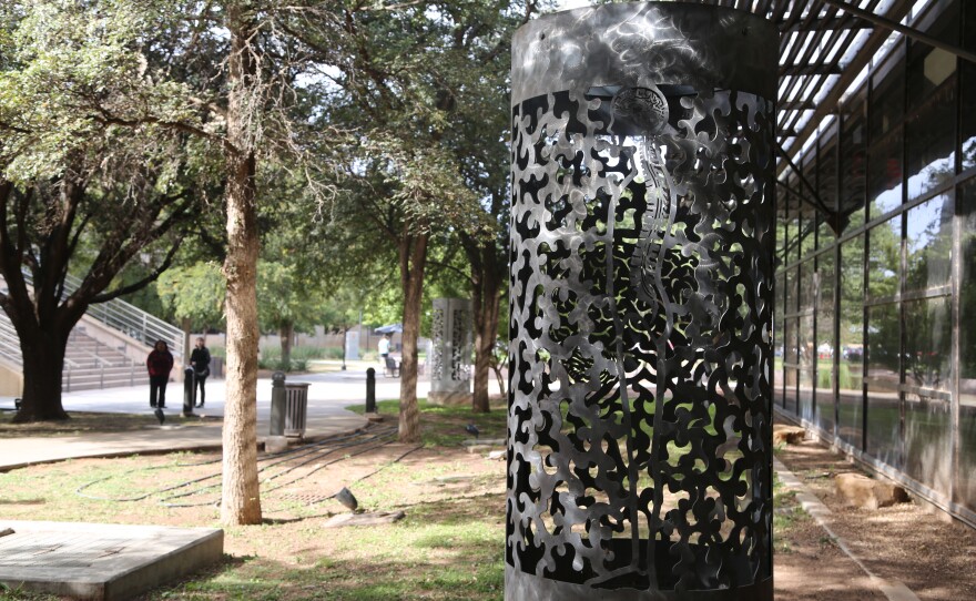 A large metal cylindrical lantern in the courtyard, depicting the human nervous system.