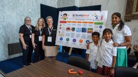 Mayukha Khambhammettu, Avik Devarapalli, and Coach Mounica Gaddampose with their project poster. 
