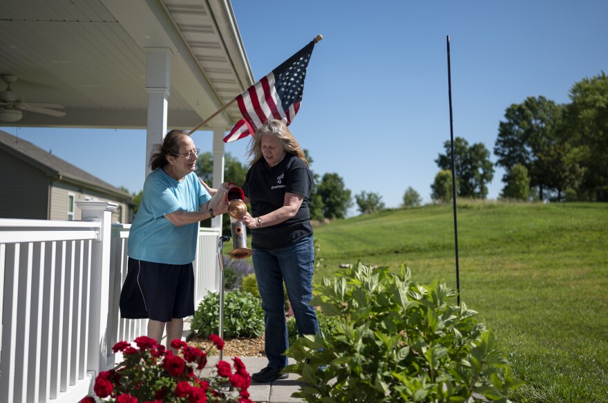 LuAnn Cooper, right, helps her client Margie refill the bird feeder in front of her home in Washington, Missouri on May 29, 2020.