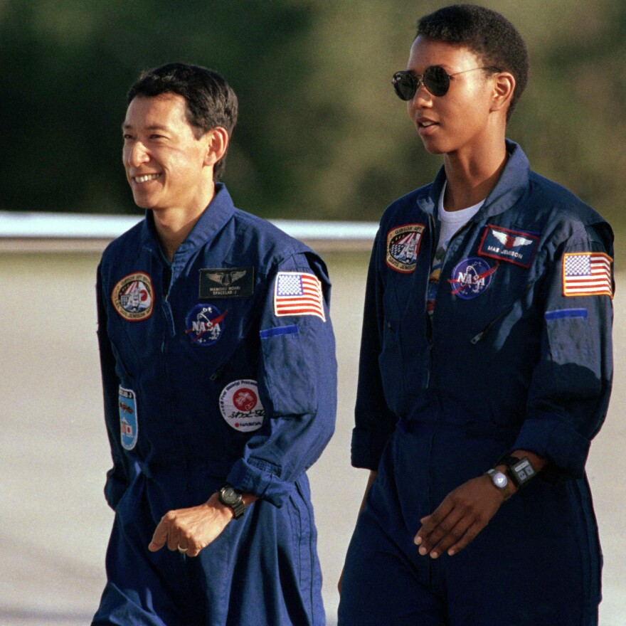 Mamoru Mohri and Mae Jemison walk together after arriving with the rest of the STS-47 crew on Sept. 9, 1992, at Kennedy Space Center in Florida.