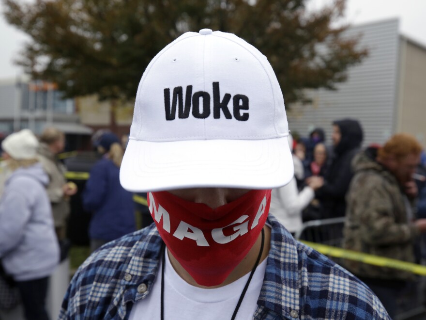 A supporter of President Donald Trump wears a "Woke" hat before a campaign rally at Lancaster Airport on Oct. 26, 2020 in Lititz, Pa.