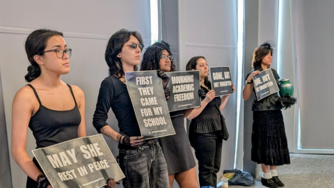 UNT students stood silently in the University of North Texas Board of Regents meeting on Thursday in Fort Worth. Faculty members seated in the gallery also held signs.