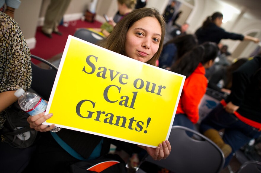 A student at the University of Pacific holds up a placard supporting Cal Grants.