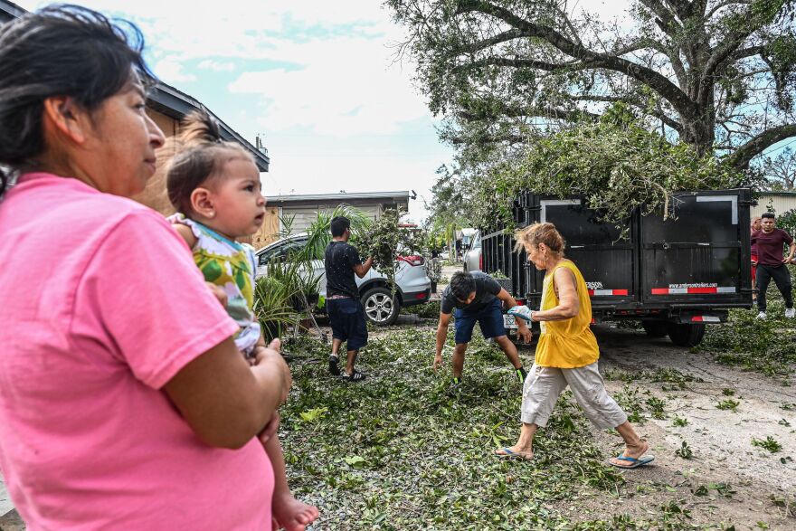 Residents of mobile homes clean up debris in the aftermath of Hurricane Ian, in Fort Myers, Fla., on Sept. 29, 2022.