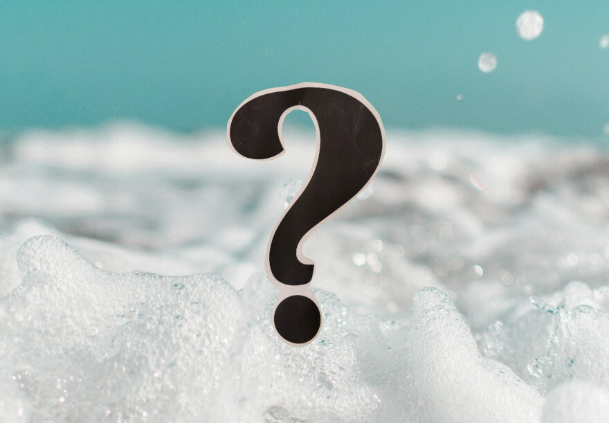 Close-up of bubbles in a bubble bath; a question mark in the foreground