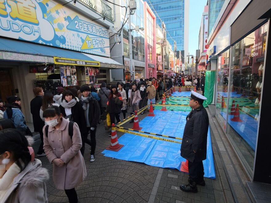 A policeman stands next to a roped-off crime scene the morning after a man drove into the crowd on New Year's Eve on Takeshita Street in Tokyo's fashion district of Harajuku on Tuesday.
