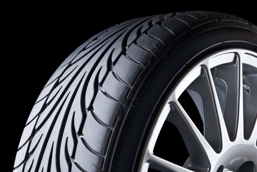 A partial view of a care tire set against a black background.