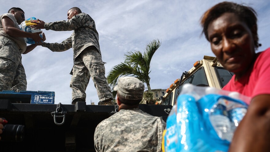 U.S. Army soldiers pass out water, provided by FEMA, to residents in a neighborhood without grid electricity or running water in San Isidro, Puerto Rico, on Oct. 17, 2017.
