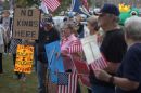 Protesters hold American flags and signs that say 'No King.'