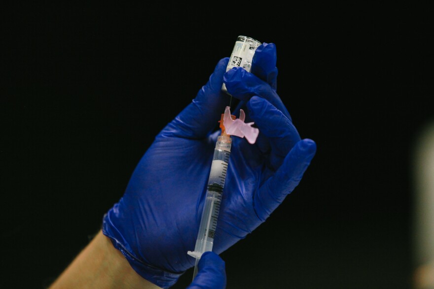 A vaccinator draws a shot of a COVID-19 vaccine.