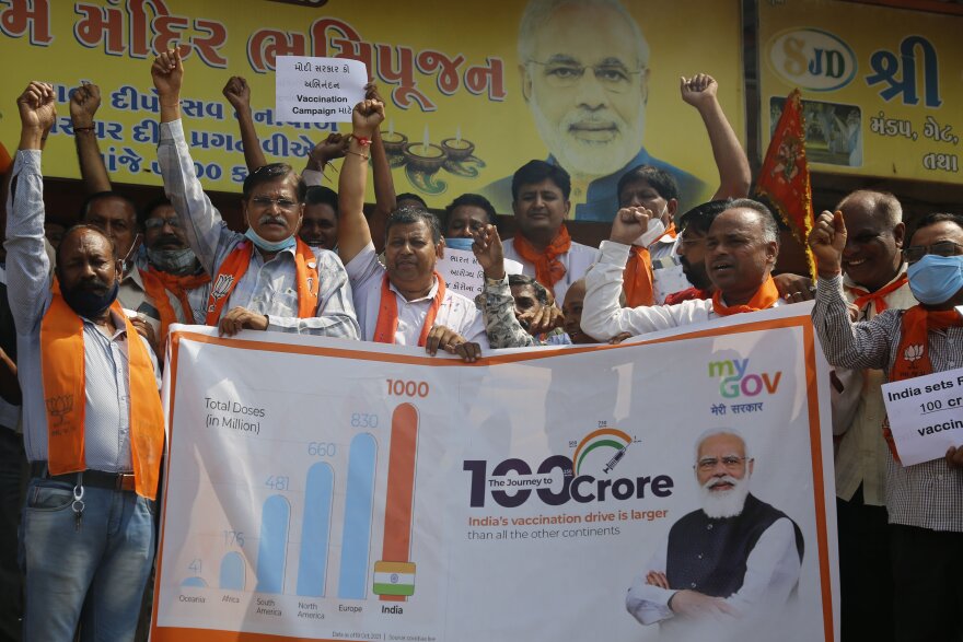 Supporters of India's ruling Bharatiya Janata Party (BJP) celebrate India administering 1 billion doses of COVID-19 vaccine in Ahmedabad, India, Thursday, Oct. 21, 2021. India has administered 1 billion doses of COVID-19 vaccine, passing a milestone for the South Asian country where the delta variant fueled its first crushing surge this year. (AP Photo/Ajit Solanki)