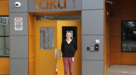 A woman stands in front of an elementary school.