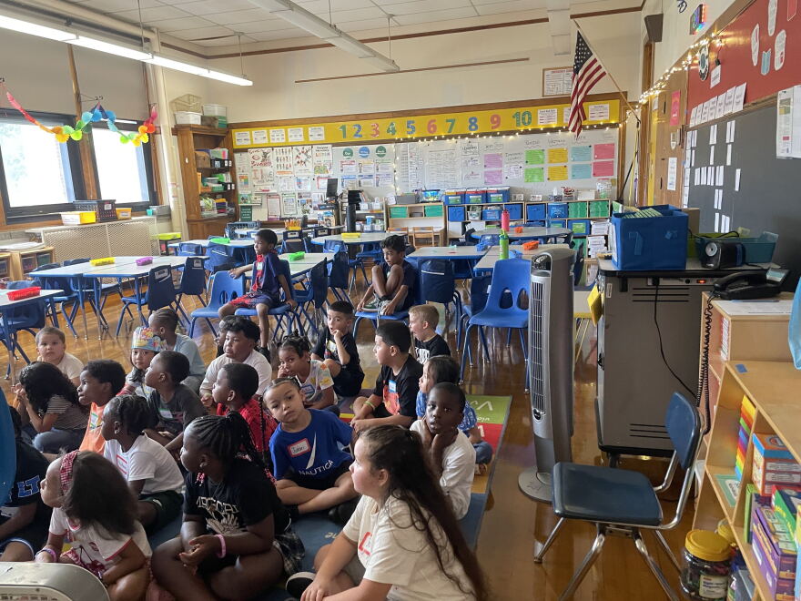 Students sit in front of an oscillating fan on the first day of school on Sept.