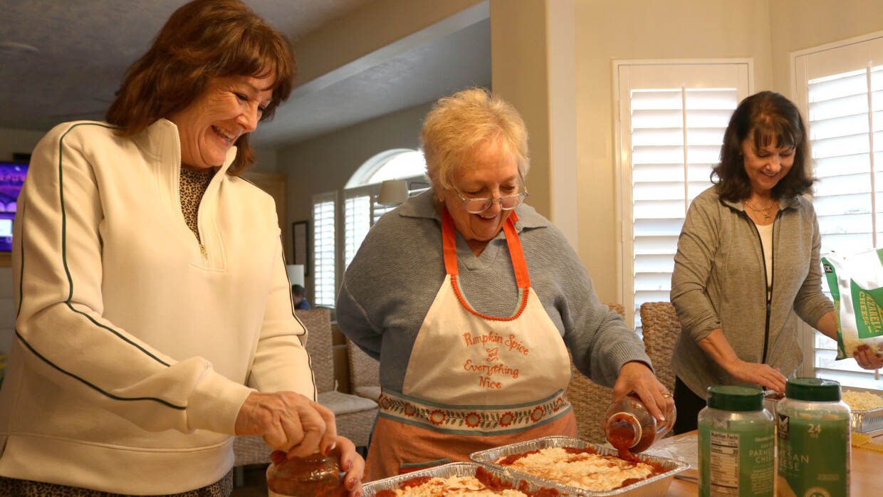 Three women top \lasagnas with sauce, Nov. 13, 2025
