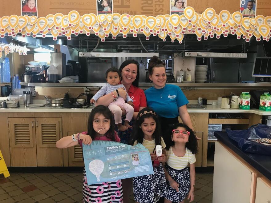 Six-year-old Izabella Neira (right) stands with her sisters, UF Health associate Lindsay Ritenbaugh (left) and an IHOP employee to celebrate National Pancake Day.