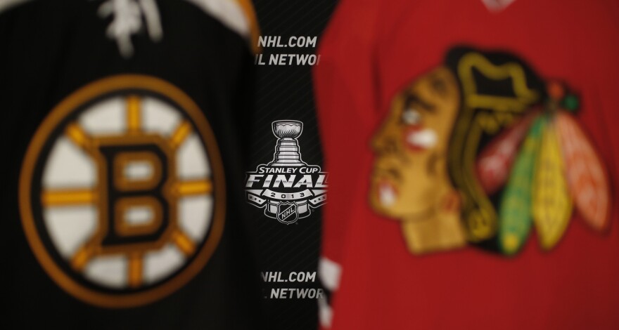 The 2013 NHL Stanley Cup logo is seen between the sweaters of the Boston Bruins and Chicago Blackhawks. The Game 1 puck drops at 8 p.m. Wednesday in Chicago.