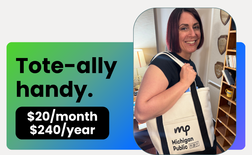 a white woman holds a black and white tote that says "michigan public"