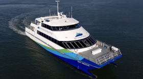 A blue and white ferry sailing in the water