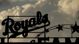 Storm clouds pass in the distance before the start of a rain-delayed Kansas City Royals game.