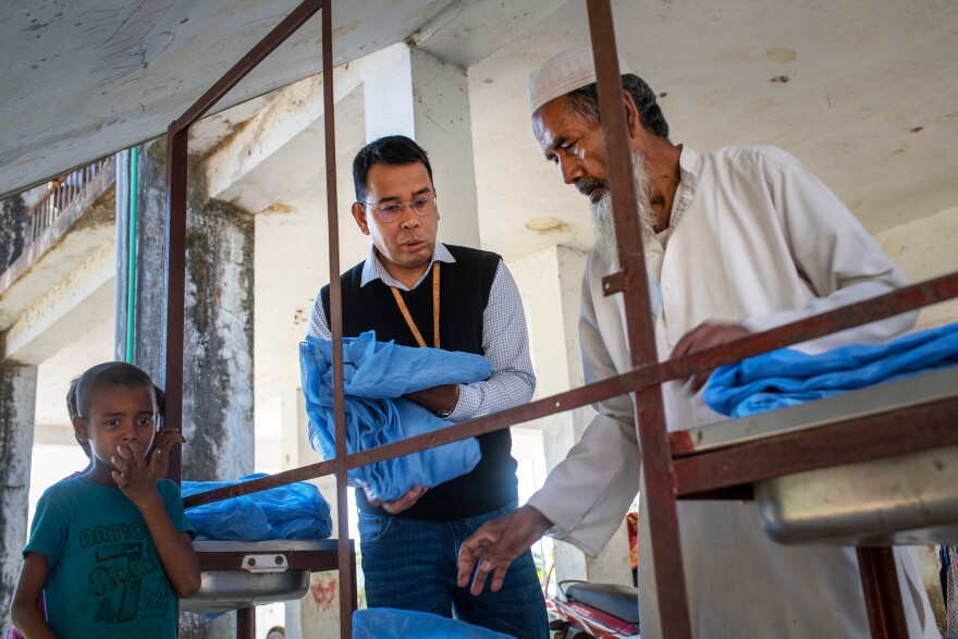 Dr. Ching Swe Phru talks with a health worker while dispersing insecticidal bed nets in Bangladesh. <strong></strong>Phru is grateful for the strides made against malaria but adds, "I'm afraid that malaria has a certain history of coming back."