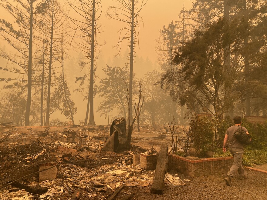 Sam Drevo walks by the burned foundation of his mother’s home in Gates following the 2020 Labor Day fires.