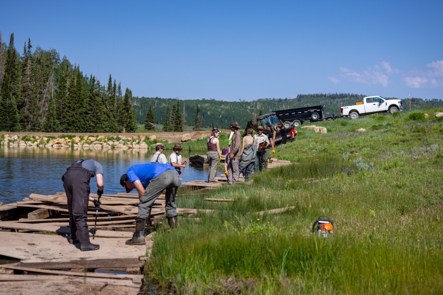 Volunteers part of the DWR's Dedicated Hunter Program help to remove a boardwalk at Beaver Dam reservoir.