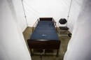 A blue hospital bed inside a temporary medical tent.