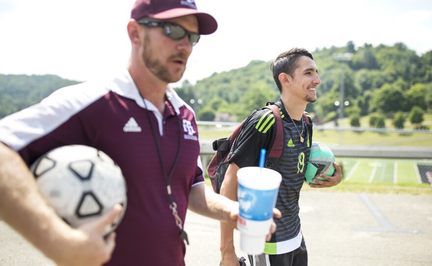 Ricardo Osuna, right, who graduated from high school this spring, and head soccer coach Troy Barkley, left, leave the Galax High School field. Osuna helped to lead the school's soccer team to the state championship title the past two years. Barkley credits the sheer love of soccer that his Hispanic players have as a contributing factor to the team's success.